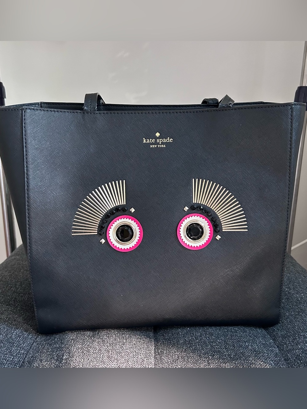 kate spade black tote with pink and silver eye embellishments
